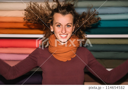 Stylish woman with curly hair in craft textile store, design concept Stylish woman with curly hair in craft textile store, design concept 114654582