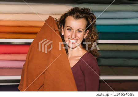Stylish woman with curly hair in craft textile store, design concept Stylish woman with curly hair in craft textile store, design concept 114654589