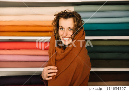 Stylish woman with curly hair in craft textile store, design concept 114654597