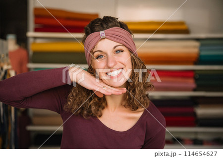 Stylish woman with curly hair in craft textile store, design concept 114654627