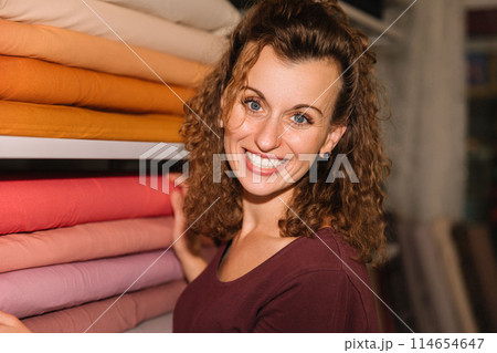 Stylish woman with curly hair in craft textile store, design concept Stylish woman with curly hair in craft textile store, design concept 114654647