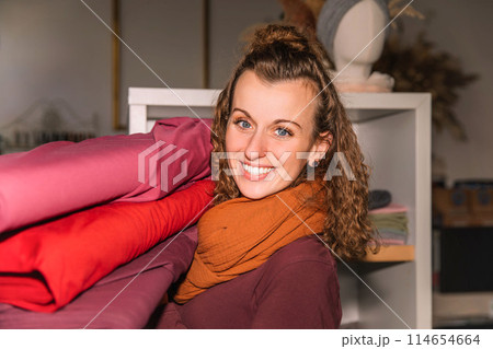 Stylish woman with curly hair in craft textile store, design concept 114654664