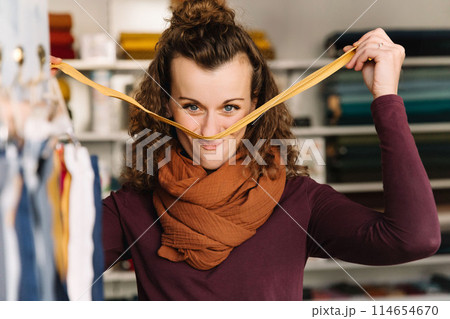 Stylish woman with curly hair in craft textile store, design concept Stylish woman with curly hair in craft textile store, design concept 114654670