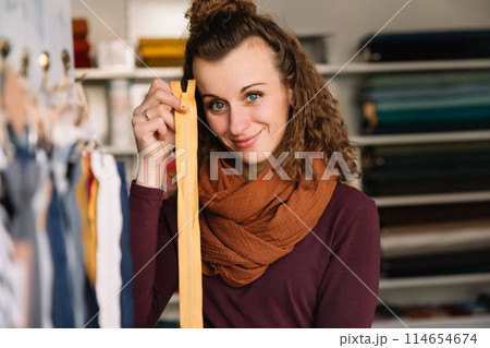 Stylish woman with curly hair in craft textile store, design concept 114654674