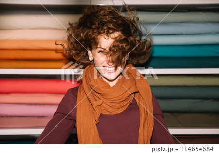 Stylish woman with curly hair in craft textile store, design concept Stylish woman with curly hair in craft textile store, design concept 114654684