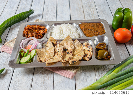 A Punjabi Thaali is a traditional meal from the Punjab region of India, known for its rich and diverse flavors. It typically consists of a variety of dishes served together on a large platter. A Punjabi Thaali is a traditional meal from the Punjab region of India, known for its rich and diverse flavors. It typically consists of a variety of dishes served together on a large platter. 114655613