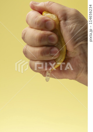 レモンを絞る 黄色背景 レモンを絞る 黄色背景 114656234