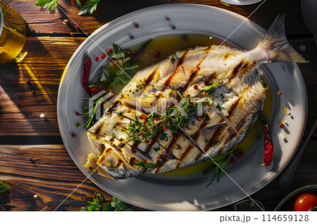 Flat lay of juicy dorado on a plate in a cafe, grilled fish, tender white flesh flakes off easily, sprinkled with aromatic olive oil and fresh herbs 114659128