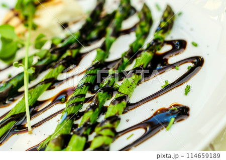 A timeless classic, asparagus spears grilled and served with a balsamic glaze, reimagined for a modern taste, perfect for any occasion. 114659189