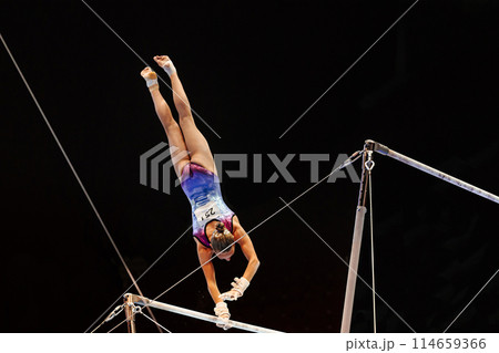 woman gymnast handstand on uneven bars gymnastics in black background 114659366