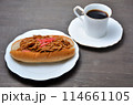 白い皿に乗ったおいしそうな焼きそばパンとコーヒー 114661105