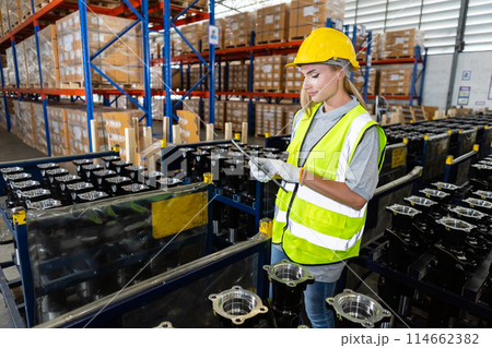 Female professional using tablet quality checking car parts worker in warehouse. 114662382