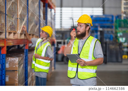 Male professional walkie talkie control worker in warehouse. Male professional walkie talkie control worker in warehouse. 114662386