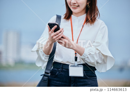 スマホを操作しながら歩く若い女性 スマホを操作しながら歩く若い女性 114663613