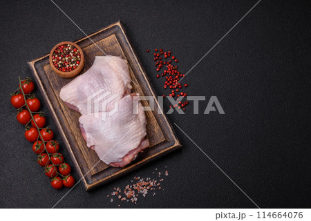 Raw chicken thighs with salt, spices and herbs Raw chicken thighs with salt, spices and herbs 114664076