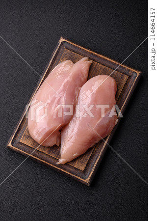 Raw chicken fillet with salt, spices and herbs Raw chicken fillet with salt, spices and herbs 114664157