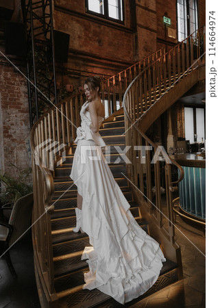 A young couple in wedding looks posing in a stylish loft bar. A young couple in wedding looks posing in a stylish loft bar. 114664974