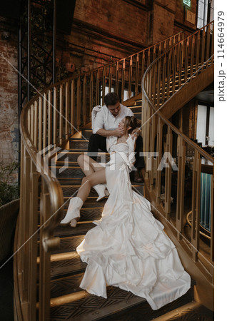 A young couple in wedding looks posing in a stylish loft bar. A young couple in wedding looks posing in a stylish loft bar. 114664979