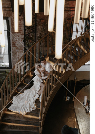 A young couple in wedding looks posing in a stylish loft bar. 114664990