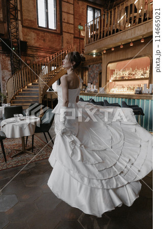 A young couple in wedding looks posing in a stylish loft bar. 114665021