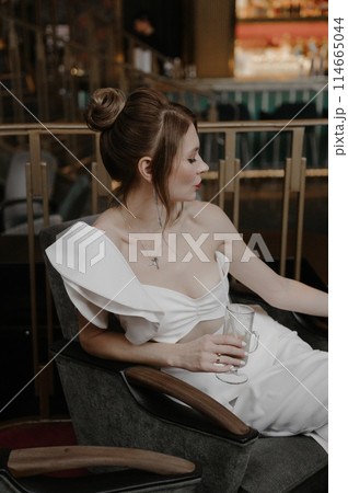 A young couple in wedding looks posing in a stylish loft bar. A young couple in wedding looks posing in a stylish loft bar. 114665044