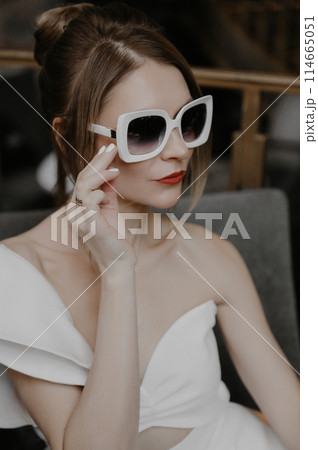 A young couple in wedding looks posing in a stylish loft bar. A young couple in wedding looks posing in a stylish loft bar. 114665051