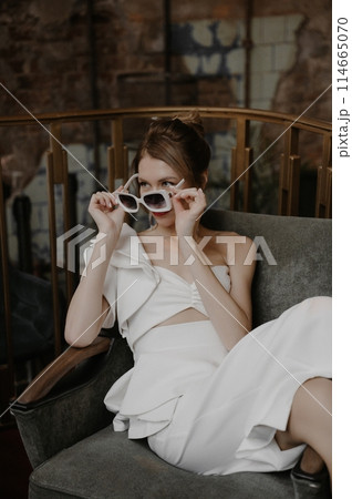 A young couple in wedding looks posing in a stylish loft bar. A young couple in wedding looks posing in a stylish loft bar. 114665070