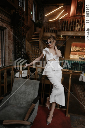 A young couple in wedding looks posing in a stylish loft bar. A young couple in wedding looks posing in a stylish loft bar. 114665162