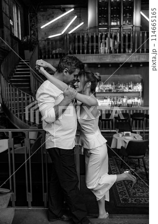 A young couple in wedding looks posing in a stylish loft bar. A young couple in wedding looks posing in a stylish loft bar. 114665165