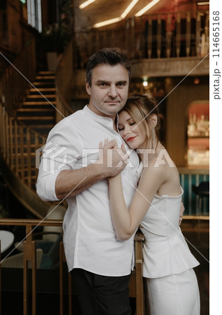 A young couple in wedding looks posing in a stylish loft bar. A young couple in wedding looks posing in a stylish loft bar. 114665168