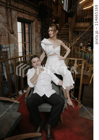 A young couple in wedding looks posing in a stylish loft bar. 114665169