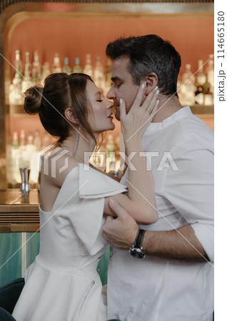 A young couple in wedding looks posing in a stylish loft bar. A young couple in wedding looks posing in a stylish loft bar. 114665180