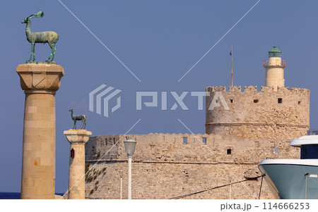 Old stone lighthouse illuminated by the sun at Fort St. Nicholas in Rhodes. 114666253
