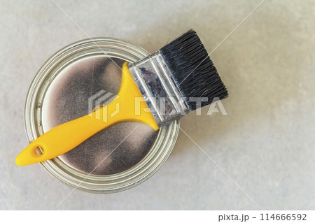 House renovation. Can with paint and a brush tool on concrete background House renovation. Can with paint and a brush tool on concrete background 114666592