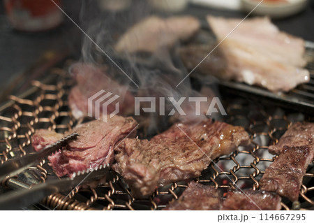 Korean Style Barbecue on stainless grill. BBQ rare meat with soft focus Korean Style Barbecue on stainless grill. BBQ rare meat with soft focus 114667295