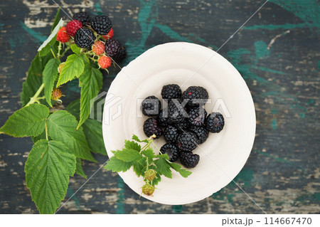 Wild black forest raspberries in a clay bowl 114667470