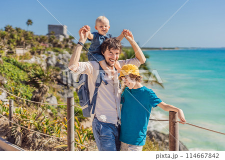 Father and two sons tourists enjoying the view Pre-Columbian Mayan walled city of Tulum, Quintana Roo, Mexico, North America, Tulum, Mexico. El Castillo - castle the Mayan city of Tulum main temple Father and two sons tourists enjoying the view Pre-Columbian Mayan walled city of Tulum, Quintana Roo, Mexico, North America, Tulum, Mexico. El Castillo - castle the Mayan city of Tulum main temple 114667842