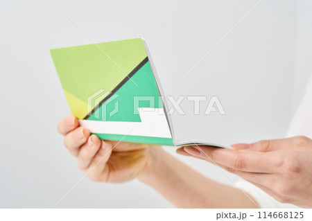 銀行の通帳を見る女性の手元 114668125