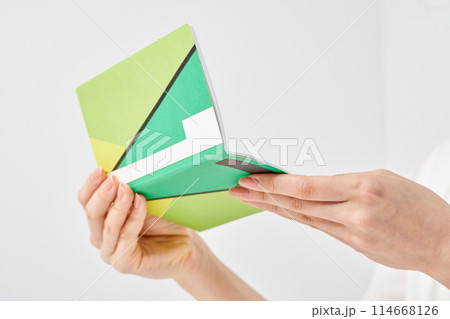 銀行の通帳を見る女性の手元 114668126