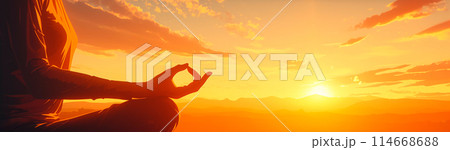 Silhouette in yoga mudra pose against a fiery sunset sky 114668688