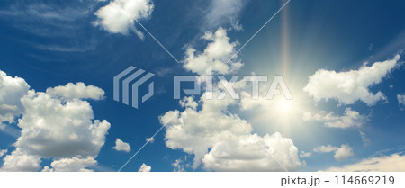 Sun on beautiful blue sky with white fluffy clouds. 114669219