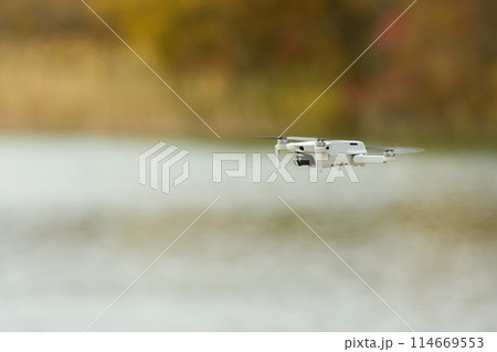 Unmanned aerial vehicle close-up against the background of an autumn landscape 114669553