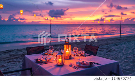 夕焼け空の下、ビーチ砂のキャンドルの上に素晴らしいロマンチックなディナー テーブル 114670774