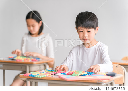 学校の教室でアルファベットのおもちゃを使って英語を勉強する小学生の男の子(低学年) 学校の教室でアルファベットのおもちゃを使って英語を勉強する小学生の男の子(低学年) 114672836