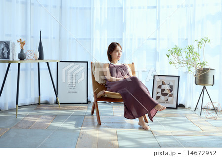 部屋の中で椅子に座って朝日を浴びてくつろぐ 部屋の中で椅子に座って朝日を浴びてくつろぐ 114672952