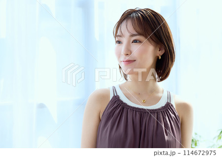 部屋の中でレースカーテン越しにくつろぐ女性 部屋の中でレースカーテン越しにくつろぐ女性 114672975