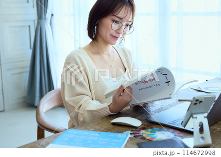 自宅でパソコンに向かって仕事をする女性デザ 114672998
