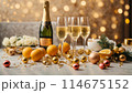 A table with champaigne bottle and glasses is covered with a variety of fruits, oranges and lemons 114675152