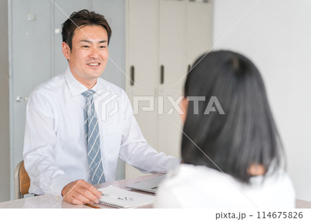 学校・塾・進学塾で個別面談をする男性教師・講師・先生と女子生徒 学校・塾・進学塾で個別面談をする男性教師・講師・先生と女子生徒 114675826