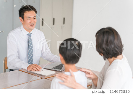 三者面談で笑顔で話をする男性担任教師と男子生徒と保護者の母親（小学生・中学生・男の子） 114675830
